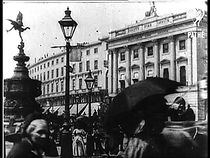 Watch Leisurely Pedestrians, Open Topped Buses and Hansom Cabs with Trotting Horses